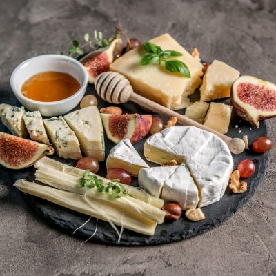 Cheese plate served with wine, nuts and honey top view
